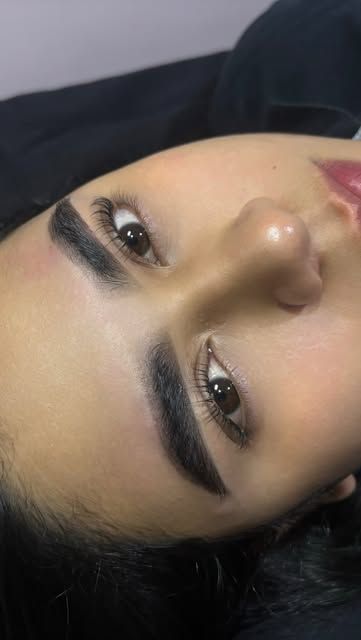 Cejas diseñadas y sombreadas de una clienta, vistas de cerca con los ojos abiertos.