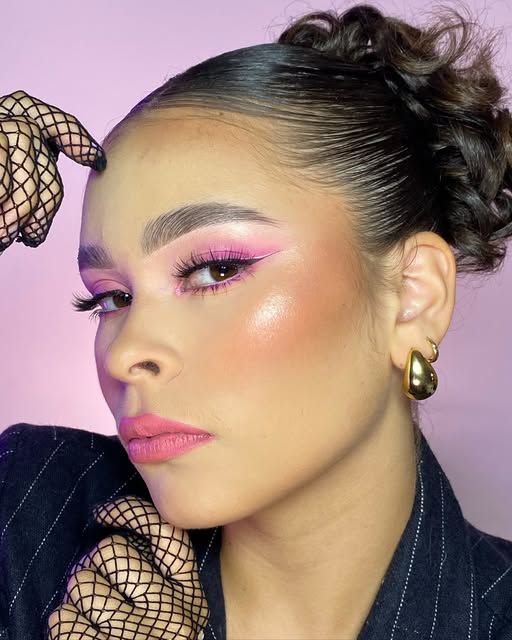 Maquillaje rosado con iluminador intenso y recogido alto.