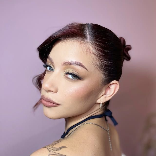 Clienta de Glow Up Studio con maquillaje soft glam y recogido, mirando por encima del hombro.